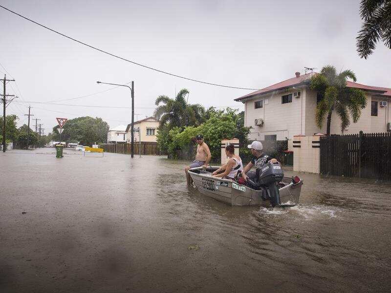 Residents navigate floodwaters in Rosslea near Townsville.