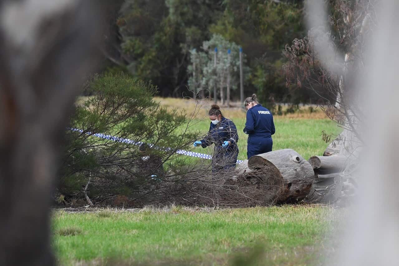 Forensic investigators are seen at work at the crime scene in Royal Park.