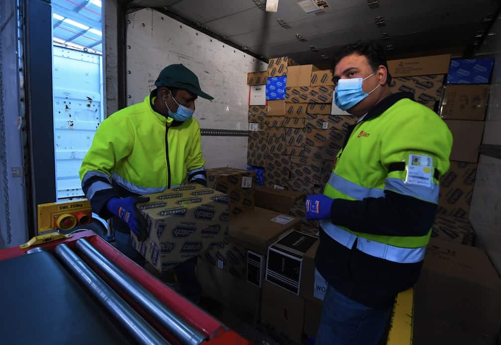 Employees load parcels into a delivery truck at Australia Post’s Sunshine West Parcel Delivery Centre in Melbourne, 16 November 2021.