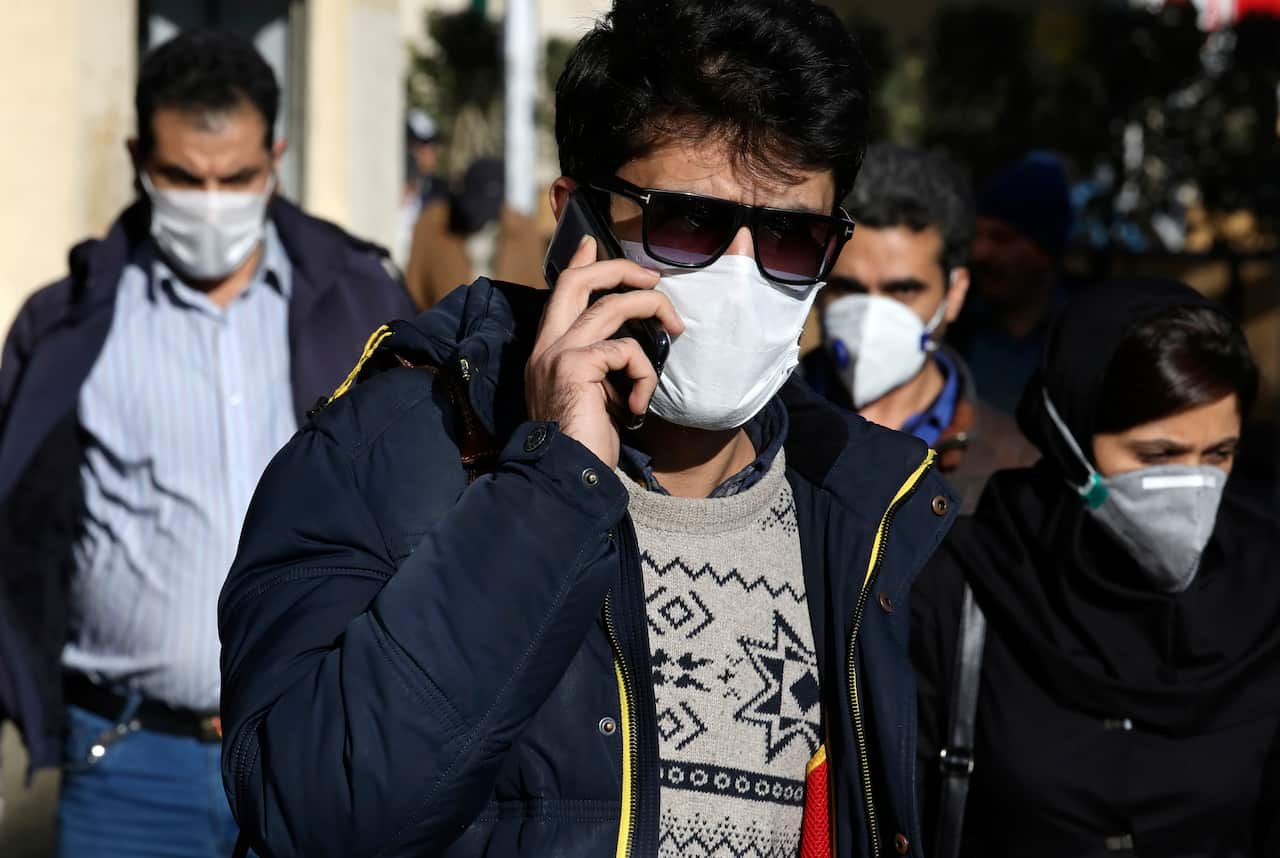 A man speaks on his cellphone wearing a face mask in downtown Tehran, Iran, Monday, 2 March, 2020.