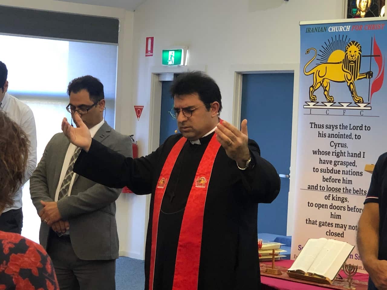 Rev John Smith leads church service behind you can see church emblem of lion and sun from Iranian flag pre revolution