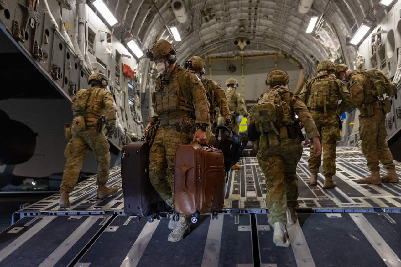 Australian Defence Force personnel unloading  luggage following an evacuation from Afghanistan