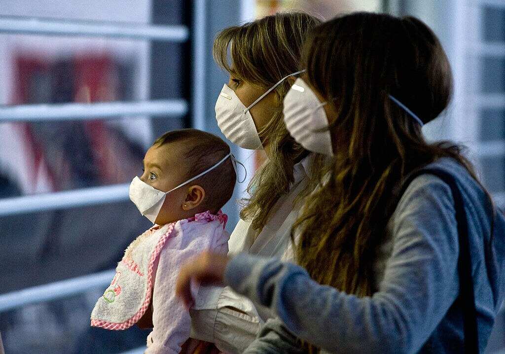 A woman and her daughters wear masks 