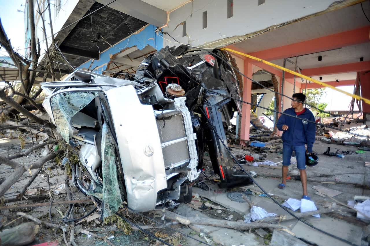 Palu residents search for families in the ruins of a house that collapsed in the recent earthquake and tsunami, near Talise Beach in Palu, Central Sulawesi, Indonesia, October,2,2018.