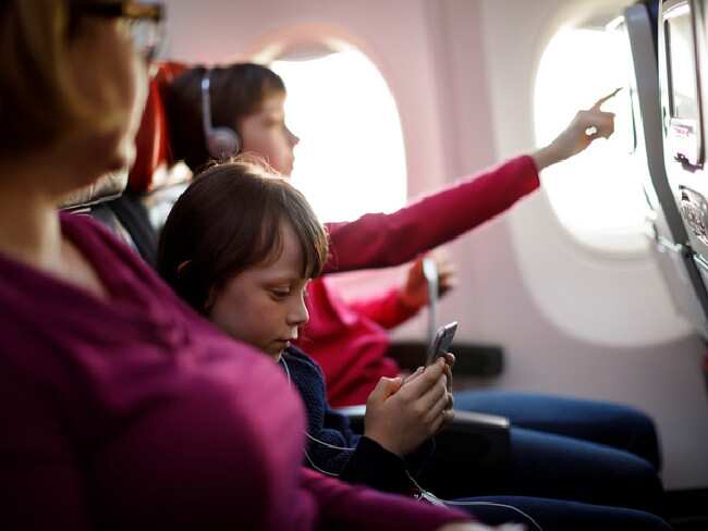 Beautiful women enjoying the flight with kids