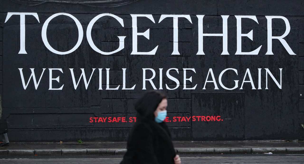 A woman passes a mural in Dublin city centre ahead of the Irish Government announcing further coronavirus restrictions.