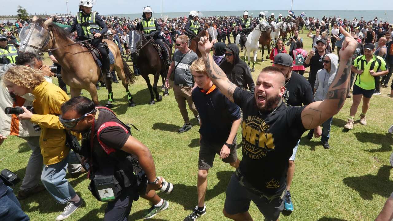 Ugly scenes at the St Kilda foreshore in Melbourne as far-right groups face off with anti-racism groups. Large group of police watch on.