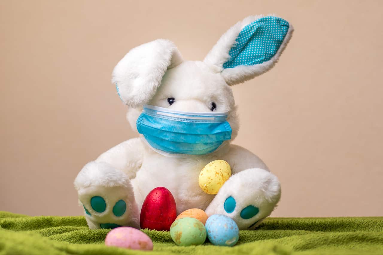 Easter bunny with easter eggs wearing a face mask