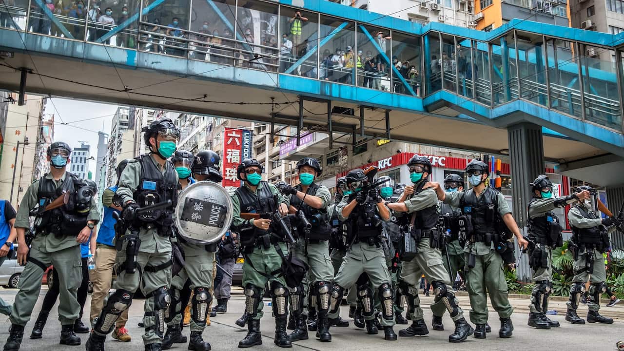 Thousands of officers guard main roads as hundreds of shoppers and tourists look on