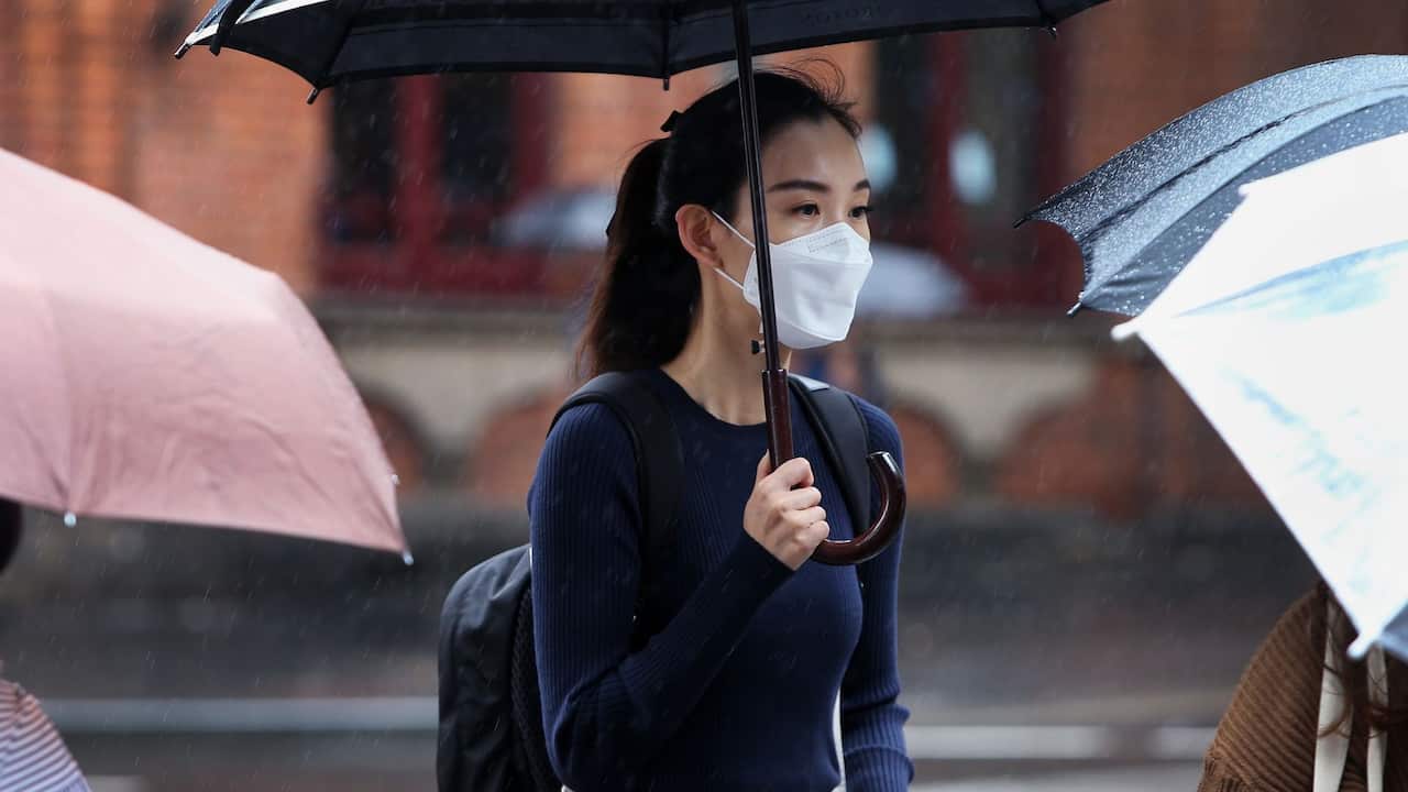 : A woman wears a face mask as she walks through the Chinatown district on March 04, 2020 in Sydney, Australia. 