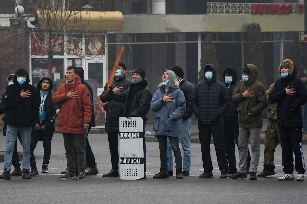 Demonstrators sing the Kazakhstan's national anthem standing in front of police line during a protest in Almaty, Kazakhstan.