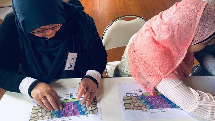 Women in the digital course learning how to use a keyboard.