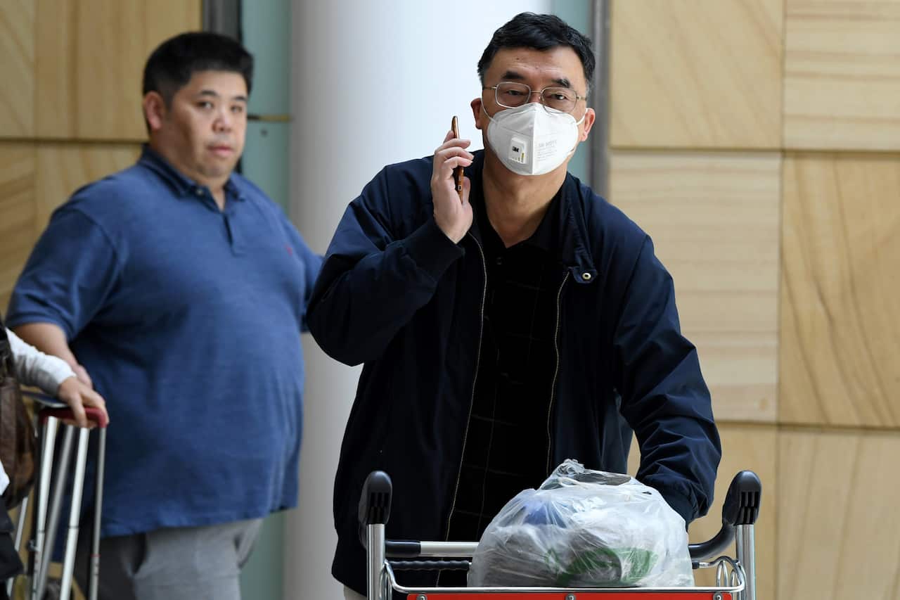 Passengers wear protective masks on arrival at Sydney International Airport.
