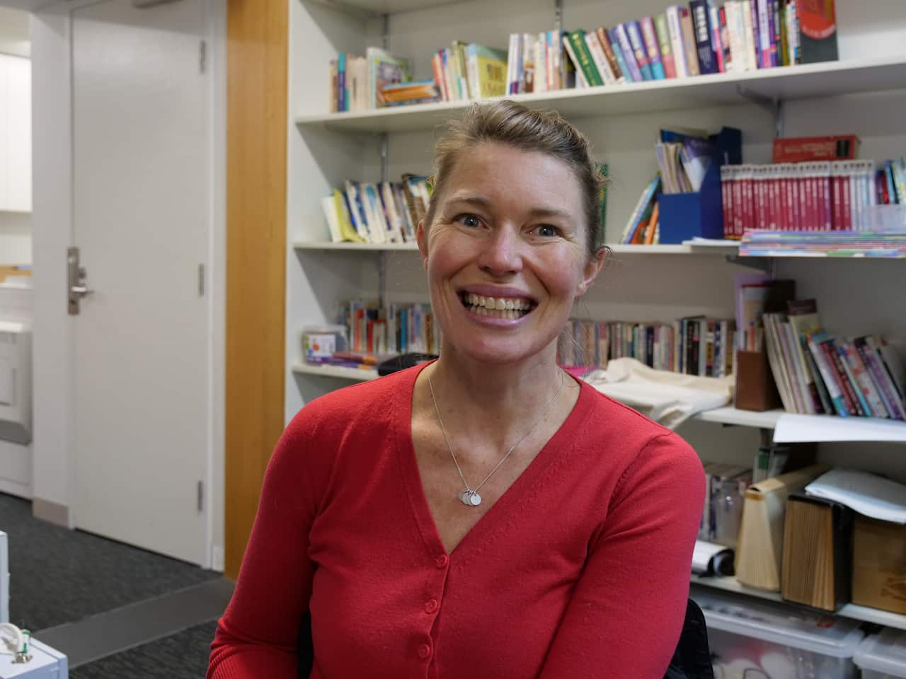 A woman with a big smile looking at the camera.