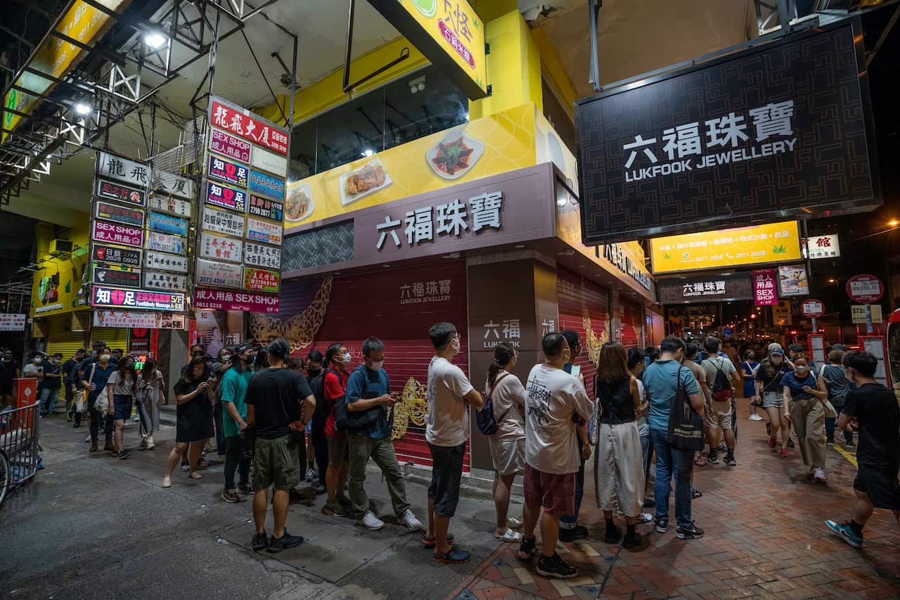 Supporters wait in line to purchase the final edition of the Apple Daily newspaper at a newsstand in Mong Kok.