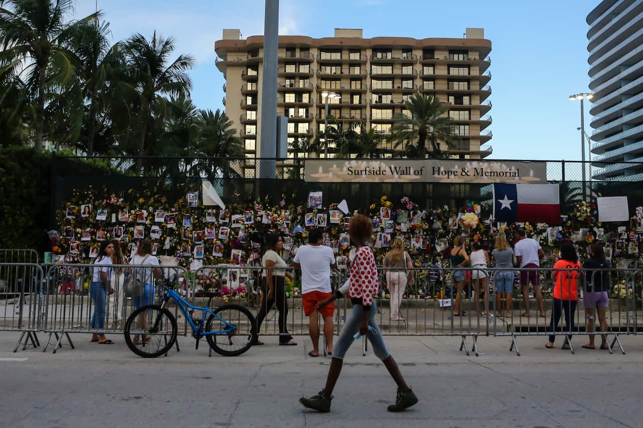 People are seen at the Surfside Wall Of Hope and Memorial on 4 July in Surfside, Florida, for victims of the building collapse.