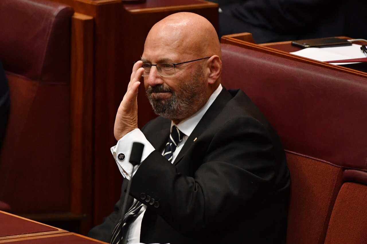 Liberal Senator Arthur Sinodinos gestures to his family during his final speech to the Senate. 