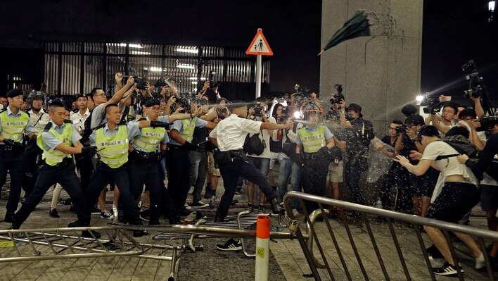 Police officers use pepper spray against protesters against the proposed amendments to the extradition law at the Legislative Council in Hong Kong (AAP)