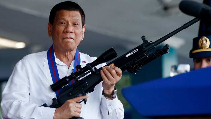 Philippine President Rodrigo Duterte holds an Israeli-made Galil rifle in suburban Quezon city northeast of Manila, Philippines. 
