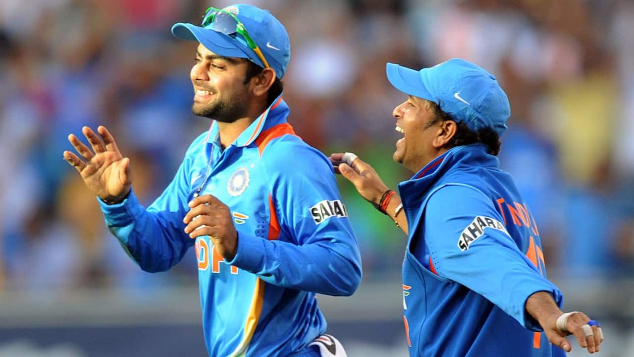 India's Virat Kohli is congratulated by teammate Sachin Tendulkar after he took the wicket of Australia's Mike Hussay during their One Day International match at the MCG in Melbourne on Sunday, Feb. 5, 2012. 