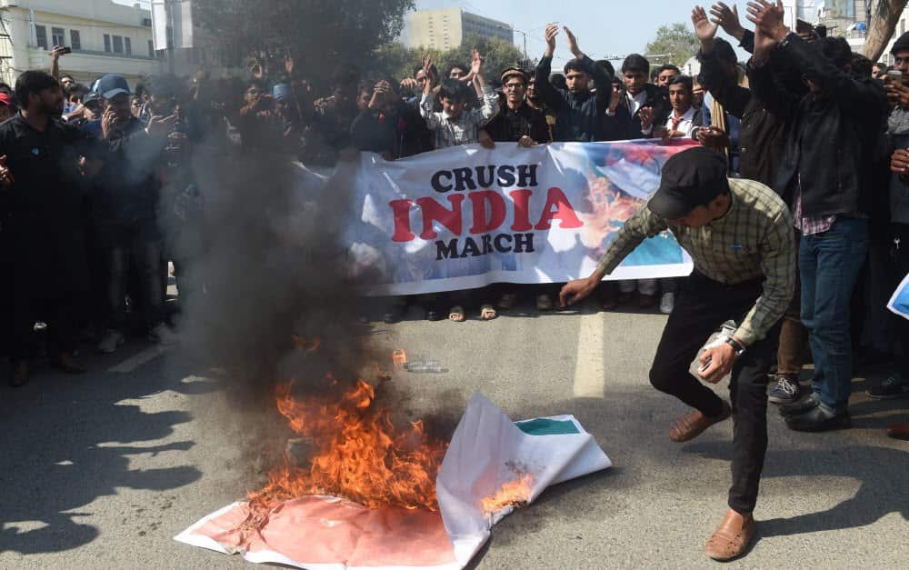 People burn portraits of Indian Prime Minister Narendra Modi during an anti-Indian protest in Lahore, Pakistan