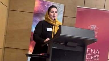 Qamaria speaking at a university event.