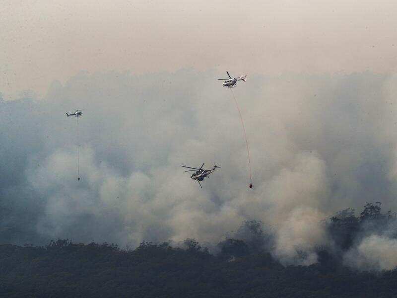Helicopters drop water on a bushfire in Gippsland, Victoria.