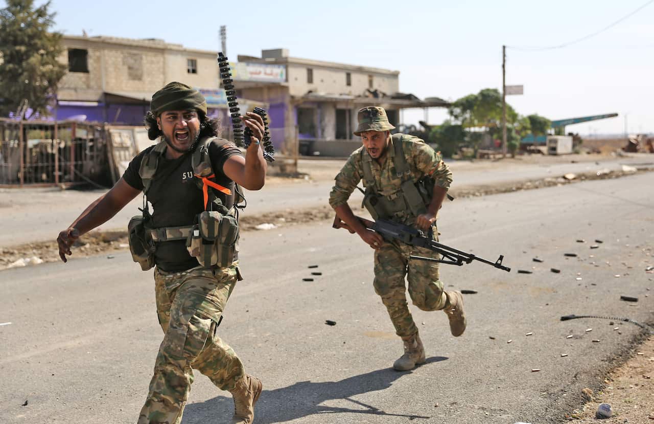 Turkish-backed Syrian fighters take part in a battle in Syria's northeastern town of Ras al-Ain 