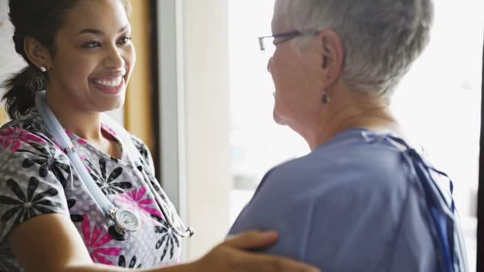 Young female doctor comforting patient in clinic