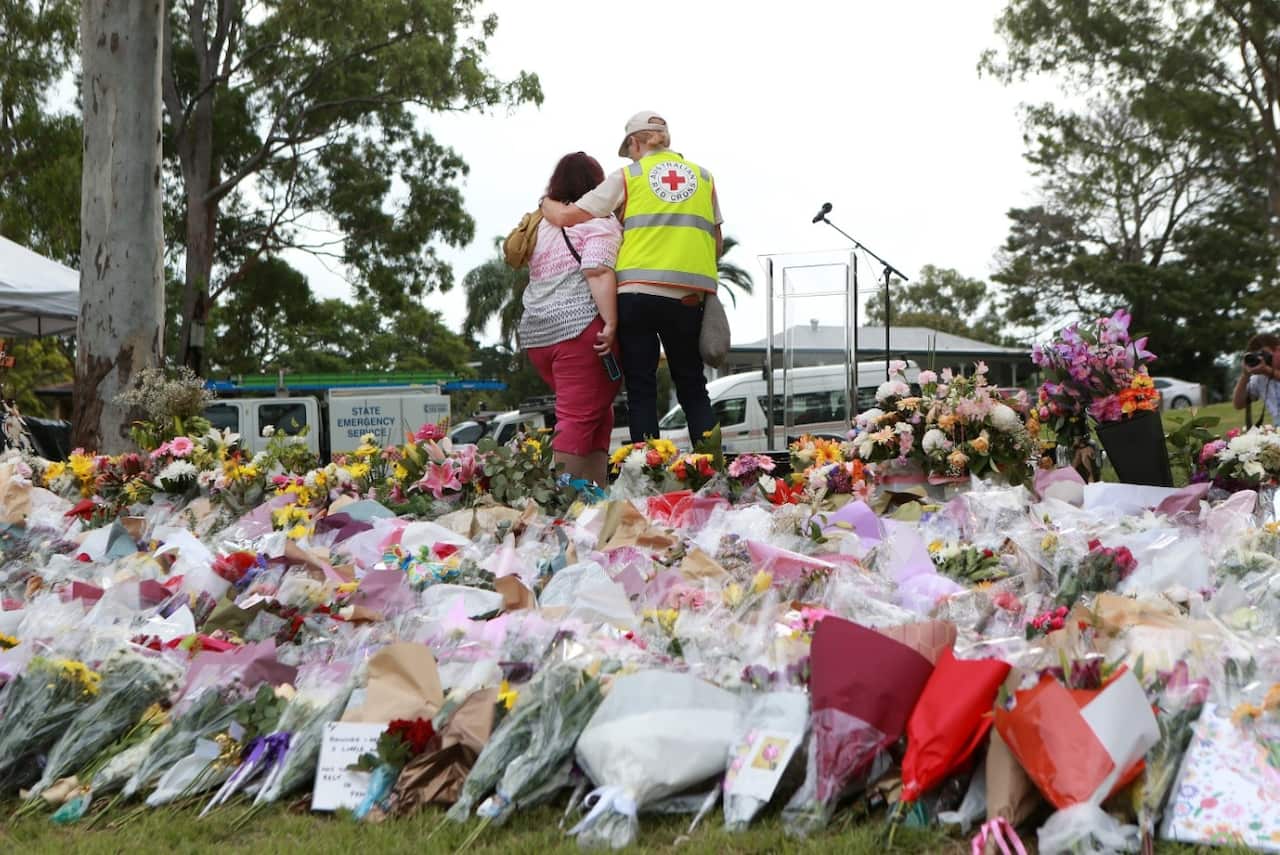 The Red Cross comforts a woman at the vigil for Hannah Clarke and her three children