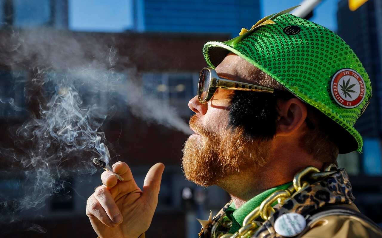Cannabis user Scott Wells smokes a joint at a rally outside governments offices following the legalisation of cannabis in Calgary.