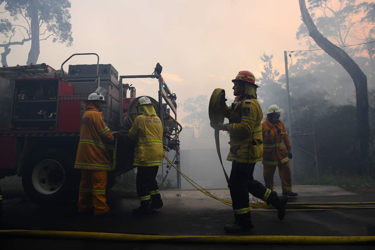 NSW Rural Fire Service personnel conduct property protection as a bushfire burns in Woodford NSW, Friday, November 8, 2019. 