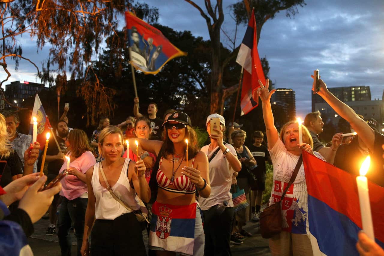 Supporters of Serbias Novak Djokovic protest and sing with candles outside the Park Hotel in the Melbourne suburb of Carlton ahead of the Australian Open in Melbourne, Australia, Thursday, Jan. 6, 2022. Djokovic had received the medical exemption he needs