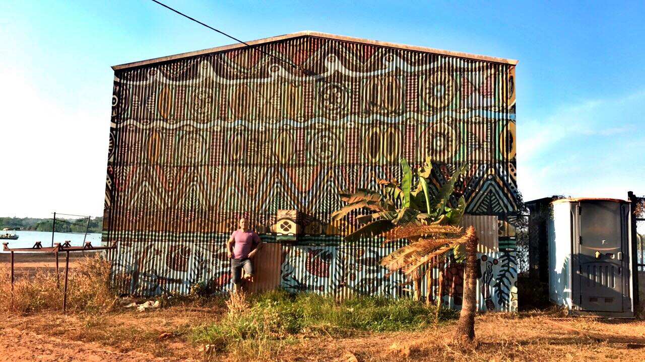 Image of Add in front of a rustic barn with aboriginal mural