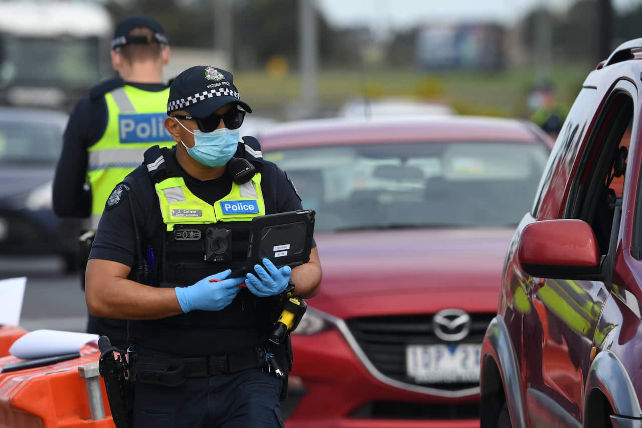 Victoria Police and ADF personnel are seen at work at a roadside checkpoint near Donnybrook, Victoria.