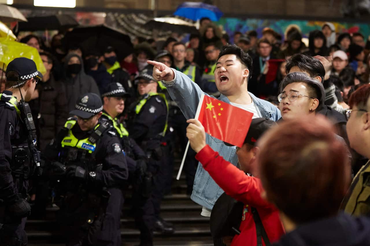 Pro-China counter protesters gesture towards Hong Kong democracy demonstrators during a rally at the State Library in Melbourne.