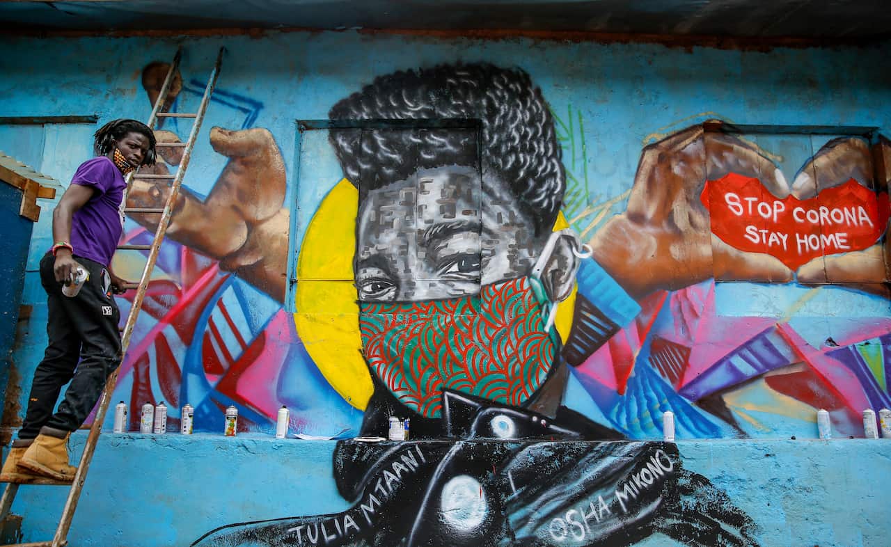 Brian Musasia Wanyande, a graffiti artist from the Mathare Roots youth group, works on an informational mural warning people about the risk of coronavirus.
