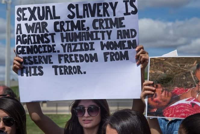 Yazidi girl holding sign