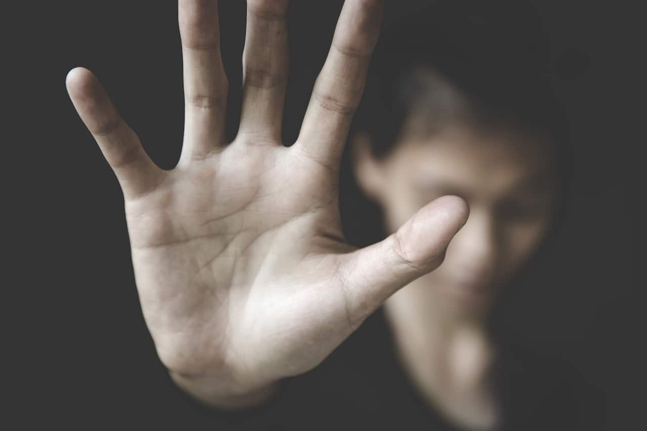 A woman raises her hand against domestic violence in this campaign photo. 