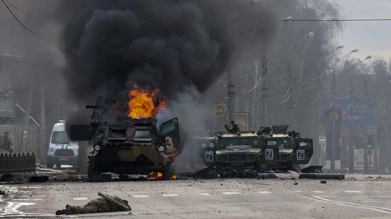 An armoured personnel carrier burns and damaged light utility vehicles stand abandoned after fighting in Kharkiv, Ukraine, Sunday, 27 February,