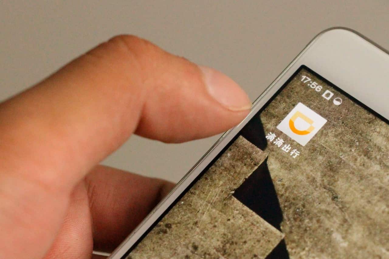 File: A local Chinese resident uses the mobile app of taxi-hailing and car service Didi Chuxing on his smartphone in Liaocheng city, east China's Shandong