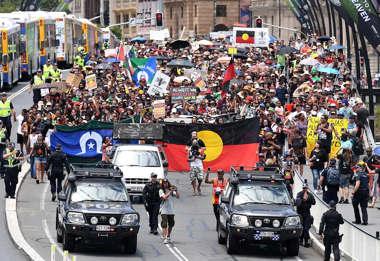 Indigenous protesters march through central Brisbane to protest what the call "Invasion Day" on Australia Day in Brisbane