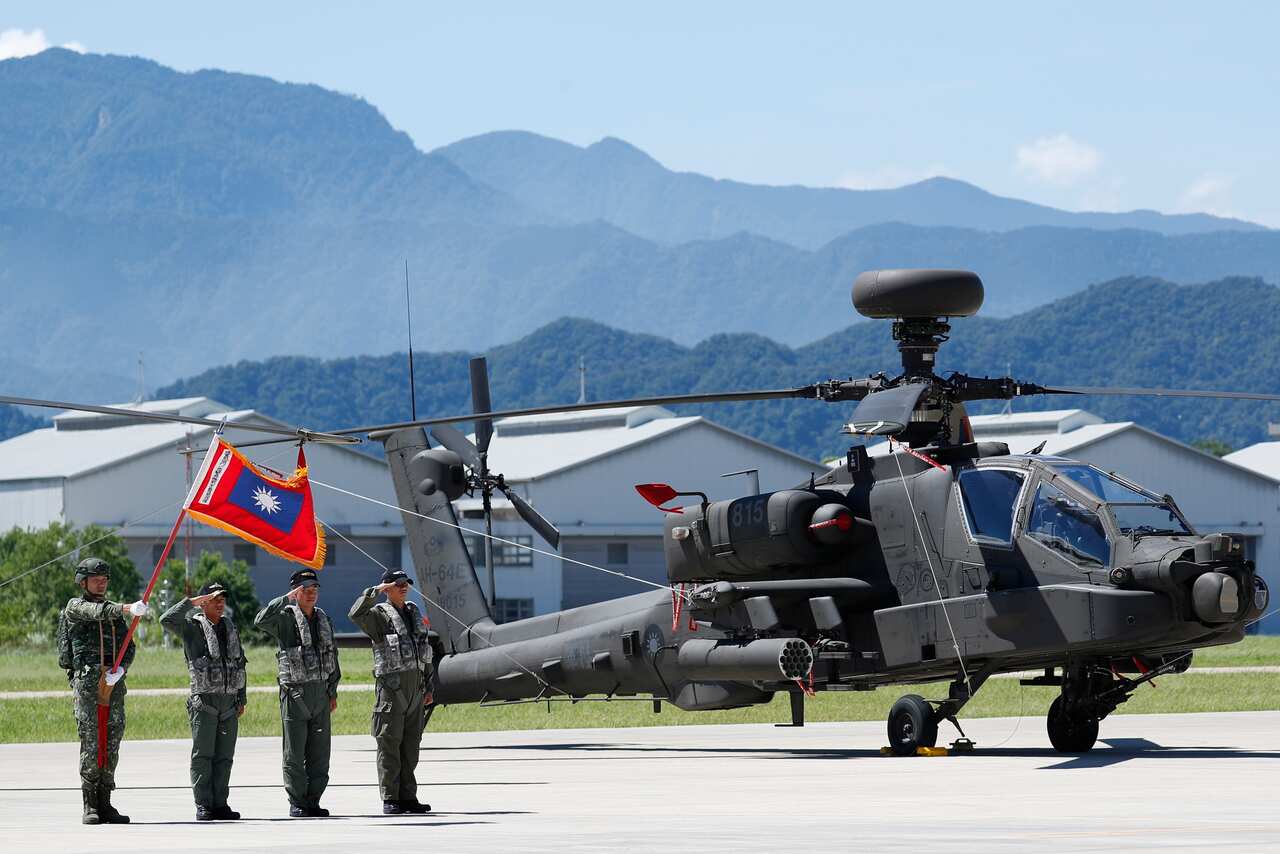 Taiwanese soldiers stand guard next to AH-1W attack helicopters in Taoyuan City, Taiwan, 17 July 2018.