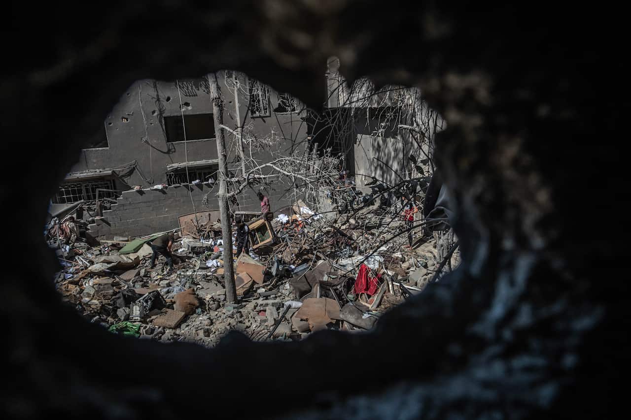 Palestinians inspect a family house at al-Shati refugee camp, west of Gaza City, after it was hit by an Israeli air strike on 15 May, 2021