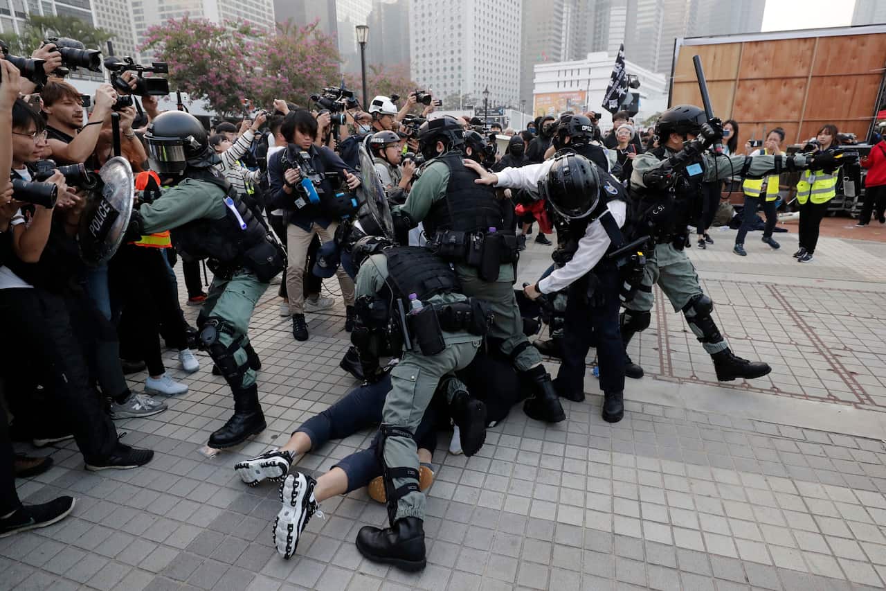 Riot policemen arrest protesters during a rally to show support for Uighurs and their fight for human rights.