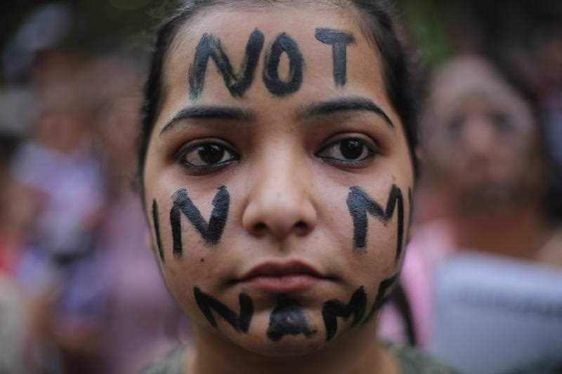 A participant has the words "not in my name" painted on face during a protest against two reported rape cases in India