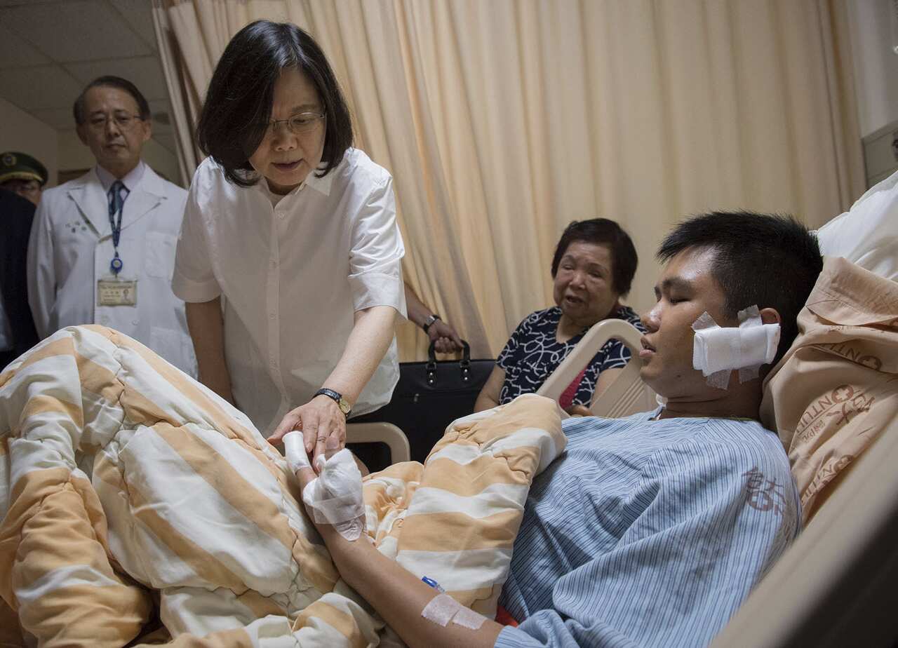 In this photo taken and released on Friday, Aug. 18, 2017, Taiwan's President Tsai Ing-wen visits an injured military guard who was attacked by a man