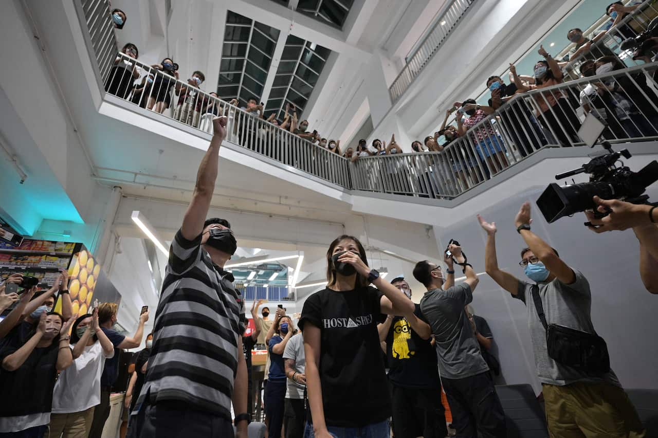 Employees cheer in the Apple Daily newspaper office atrium after completing editing on the newspaper's final edition late on 23 June, 2021.