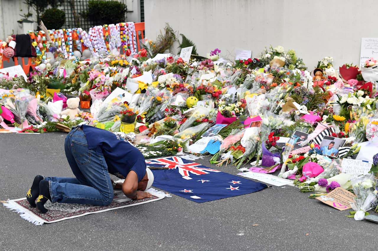 A Muslim worshipper prays at a makeshift memorial outside the Al Noor Mosque in Christchurch.