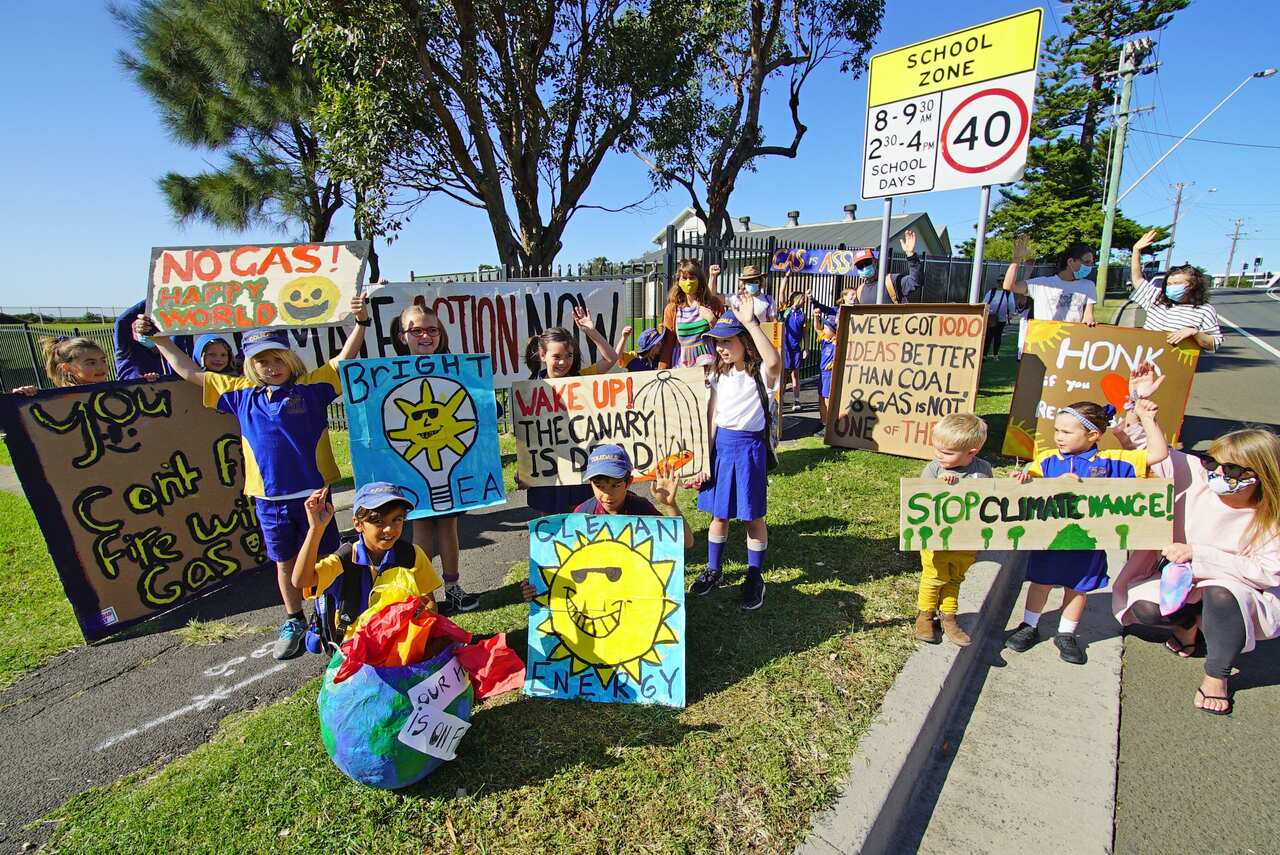 Illawara school students gather holding signs protesting renewable energy. 